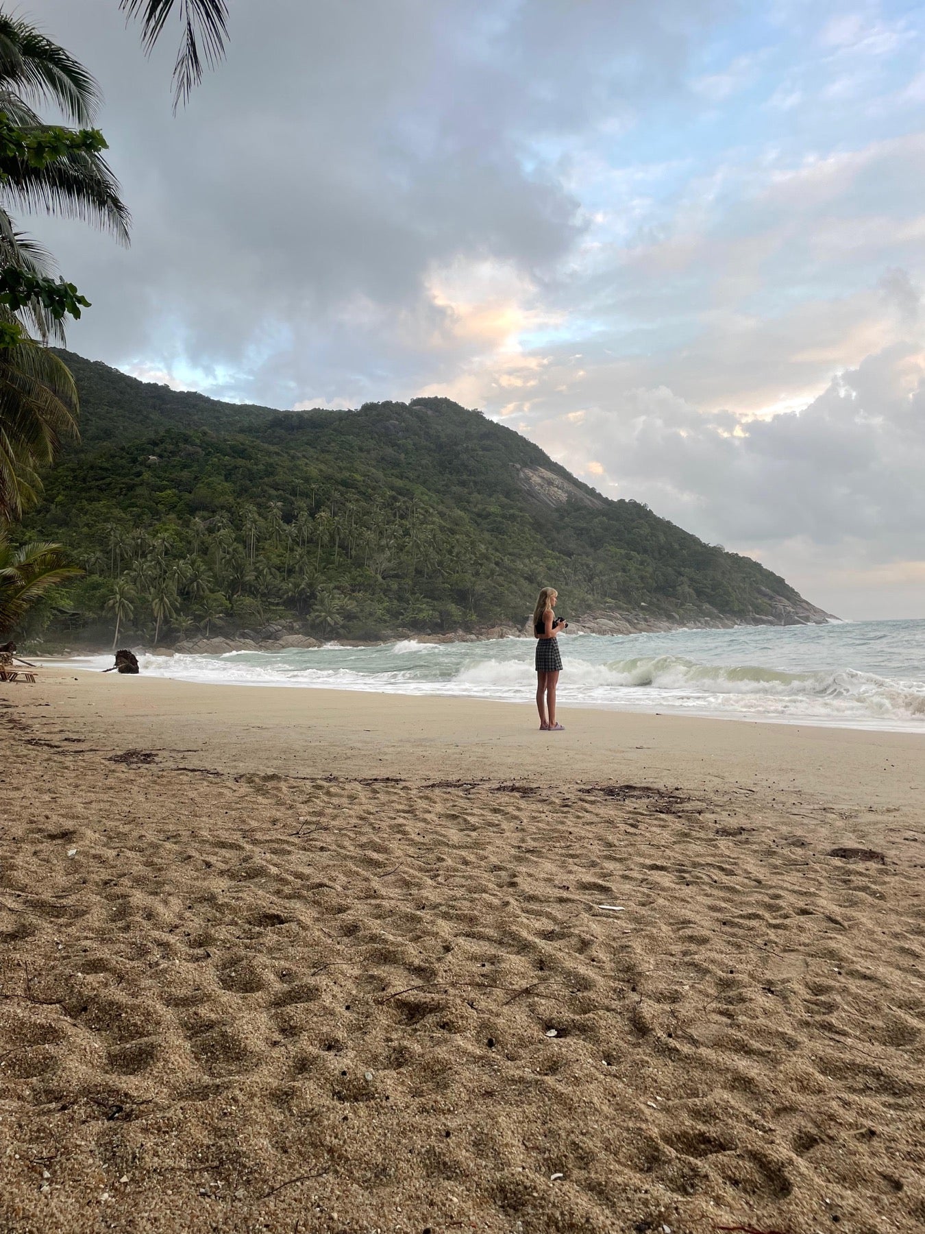 Traveller with a camera on a beach at dusk